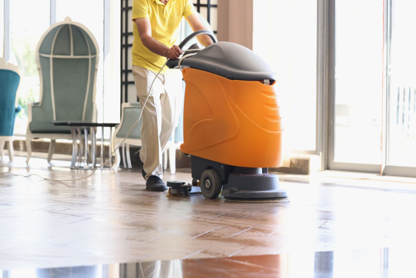 someone using cleaning machine to clean floors